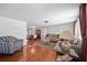 Spacious living room with hardwood floors, comfortable seating, and a view into the dining area at 5821 Thrush Dr, New Port Richey, FL 34652