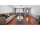 Cozy living room featuring hardwood floors, a plush sofa, and a glass coffee table at 5821 Thrush Dr, New Port Richey, FL 34652