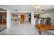 Living room area with tile flooring, a bar, shelving, and access to a dining area and kitchen at 5821 Thrush Dr, New Port Richey, FL 34652