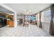Open-concept living room features tiled floors, a ceiling fan, and access to the kitchen and bar at 5821 Thrush Dr, New Port Richey, FL 34652