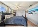 Spacious main bedroom featuring hardwood floors, a ceiling fan, and a large window for natural light and fresh air at 5821 Thrush Dr, New Port Richey, FL 34652