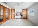 A sun room with a ceiling fan, windows, white walls, and doors opening to the living area at 5821 Thrush Dr, New Port Richey, FL 34652