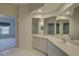 Well-lit bathroom features a dual-sink vanity, tile floor, and access to an additional bedroom at 6330 99Th N Way # 14F, St Petersburg, FL 33708