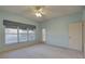 Bedroom with ceiling fan, exterior access door, and large window providing natural light and ventilation at 6330 99Th N Way # 14F, St Petersburg, FL 33708
