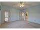 Bright bedroom featuring neutral walls, carpeting, an exterior access door, and an adjoining bath at 6330 99Th N Way # 14F, St Petersburg, FL 33708