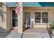 Welcoming condo entrance featuring a flag, screen door, and a well-lit entryway at 6330 99Th N Way # 14F, St Petersburg, FL 33708