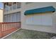 View of condo building with green awnings and storm shutters installed over the windows at 6330 99Th N Way # 14F, St Petersburg, FL 33708