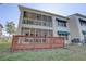 View of condo building featuring an elevated wooden deck, screened in porch and second story screened in balcony at 6330 99Th N Way # 14F, St Petersburg, FL 33708