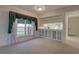 Open living room with pass-through to kitchen and built-in shelving with glass doors provides ample storage space at 6330 99Th N Way # 14F, St Petersburg, FL 33708