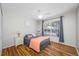 Cozy bedroom with wood floors, a ceiling fan, and a large window at 709 47Th E St, Bradenton, FL 34208