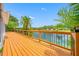 Large wooden deck overlooks lake with palm trees at 709 47Th E St, Bradenton, FL 34208