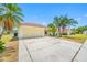A lovely home features an attached garage, lush lawn, and mature palm trees at 709 47Th E St, Bradenton, FL 34208
