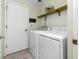 Laundry room with a side-by-side washer and dryer and storage shelf at 709 47Th E St, Bradenton, FL 34208