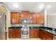 Well-equipped kitchen with stainless steel appliances, granite countertops, and wooden cabinets at 7310 Brightwater Oaks Dr, Tampa, FL 33625