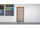 Exterior view of unit 106 front door with a peep hole and a window, set in a neutral painted wall at 7625 Sun Island S Dr # 106, South Pasadena, FL 33707