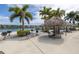 Outdoor picnic area features barbecue grills, tiki huts, and tables with water views at 7625 Sun Island S Dr # 106, South Pasadena, FL 33707