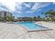 Inviting community pool surrounded by palm trees, lounge chairs, and well-maintained landscaping for relaxation at 7625 Sun Island S Dr # 106, South Pasadena, FL 33707