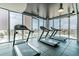 Bright gym showcasing treadmills with city views through expansive windows for a motivating workout experience at 777 N Ashley Dr # 2603, Tampa, FL 33602