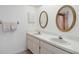 Bathroom with a double sink vanity, white countertops, and oval mirrors at 8005 Bardmoor Pl # 102I, Seminole, FL 33777