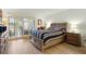 Comfortable bedroom with sliding glass doors to balcony, neutral color scheme, and wood-style floors at 8005 Bardmoor Pl # 102I, Seminole, FL 33777