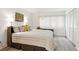 Bedroom featuring a large window with blinds, light neutral bedding, and hardwood-style floors at 8005 Bardmoor Pl # 102I, Seminole, FL 33777