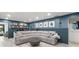 Open-concept living room with an L-shaped sofa, a coffee bar, and an accent wall with art at 820 Hickory Ln, Palm Harbor, FL 34683