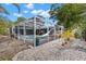 Screened-in pool surrounded by lush landscaping offers privacy and a serene outdoor living space at 820 Hickory Ln, Palm Harbor, FL 34683
