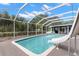 Beautiful, screened-in pool with a slide and lush landscaping provides a private backyard oasis at 820 Hickory Ln, Palm Harbor, FL 34683