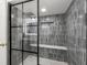 This bathroom features a walk-in shower with grey, stacked tile and a black framed glass enclosure at 820 Hickory Ln, Palm Harbor, FL 34683