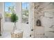 Bright bathroom featuring marble tile shower, gold fixtures, and natural light at 101 Ponce De Leon Blvd, Belleair, FL 33756