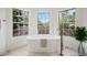 Elegant bathroom features a free-standing tub with bronze fixtures and abundant natural light at 101 Ponce De Leon Blvd, Belleair, FL 33756
