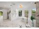 Airy bathroom with garden tub, glass shower, and marble tile floors at 101 Ponce De Leon Blvd, Belleair, FL 33756