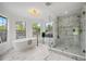 Bright, marble bathroom with a free-standing tub, elegant shower, and sun-filled windows at 101 Ponce De Leon Blvd, Belleair, FL 33756