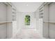 This walk-in closet has custom shelving, drawers, and an arched window providing natural light at 101 Ponce De Leon Blvd, Belleair, FL 33756
