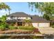 Charming two-story home with a manicured lawn, mature trees, and a three-car garage at 101 Ponce De Leon Blvd, Belleair, FL 33756