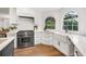 This immaculate kitchen features stainless steel appliances, white cabinets, and beautiful hardwood floors at 101 Ponce De Leon Blvd, Belleair, FL 33756