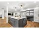 Kitchen with gray island, stainless steel refrigerator, gold fixtures, and hardwood flooring at 101 Ponce De Leon Blvd, Belleair, FL 33756