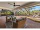 Inviting screened-in patio with a ceiling fan, comfortable seating, a pool, a hot tub, and a sun deck at 101 Ponce De Leon Blvd, Belleair, FL 33756