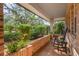 A quaint covered porch adorned with rocking chairs and surrounded by lovely landscaping at 101 Ponce De Leon Blvd, Belleair, FL 33756