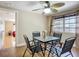 Comfortable dining area with a ceiling fan and glass-top table, adjacent to an open doorway at 10931 110Th Ave, Largo, FL 33778
