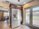 A kitchen features stainless steel refrigerator and access to the backyard through French doors at 10931 110Th Ave, Largo, FL 33778