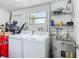 Functional laundry room equipped with a washer, dryer, and storage shelves for supplies at 10931 110Th Ave, Seminole, FL 33778