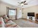 Well-lit living room with tile floors, ceiling fan, and a comfortable seating area at 10931 110Th Ave, Seminole, FL 33778