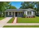 Charming home featuring a well-manicured lawn, stone accents, and a welcoming entrance at 10931 110Th Ave, Seminole, FL 33778