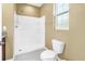 Bathroom with a shower featuring updated fixtures, a toilet, and a small window at 1116 Martin Luther King Jr Ave, Dunedin, FL 34698