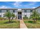Charming two-story condo with a well-manicured lawn, mature palm trees, and welcoming entryway at 112 W Cypress Ct, Oldsmar, FL 34677