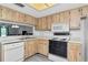 Functional kitchen with wooden cabinets, standard appliances, and a pass-through window to another room at 112 W Cypress Ct, Oldsmar, FL 34677