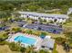 Aerial view of condo buildings with a community pool, lounge chairs, and lush landscaping at 112 W Cypress Ct, Oldsmar, FL 34677