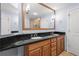 Bathroom featuring double sinks with dark countertops, light-colored cabinetry, and oversized mirror at 1227 E Madison St # 902, Tampa, FL 33602