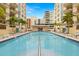 A long shot shows a pool with lounge chairs around the edge and palm trees offering shade at 1227 E Madison St # 902, Tampa, FL 33602